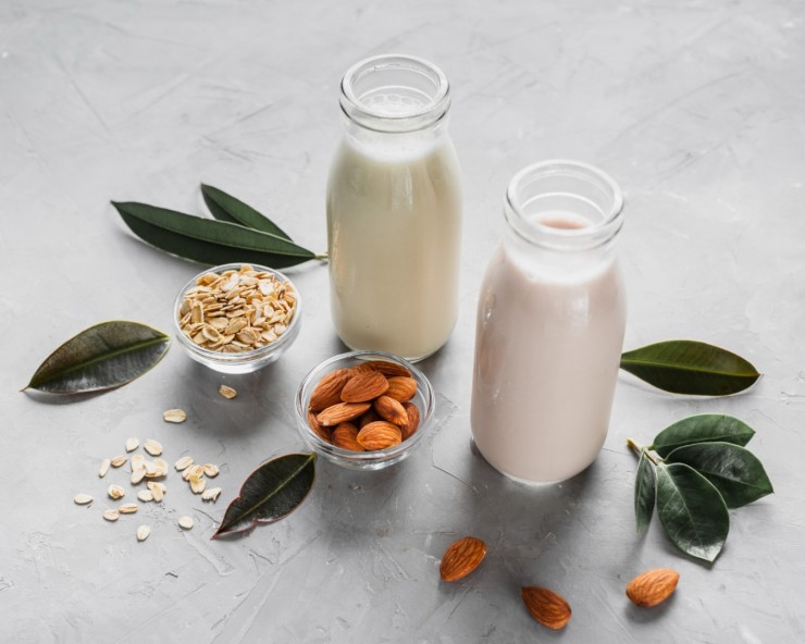 high-angle-milk-bottles-with-almonds-oats