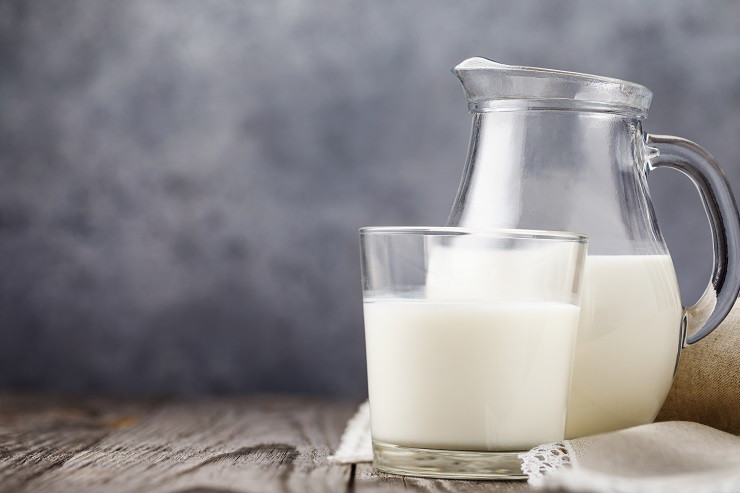 polnyi-stakan-moloka-i-prozracnyi-kuvsin-na-derevannom-stole-s-kopiei-prostranstva