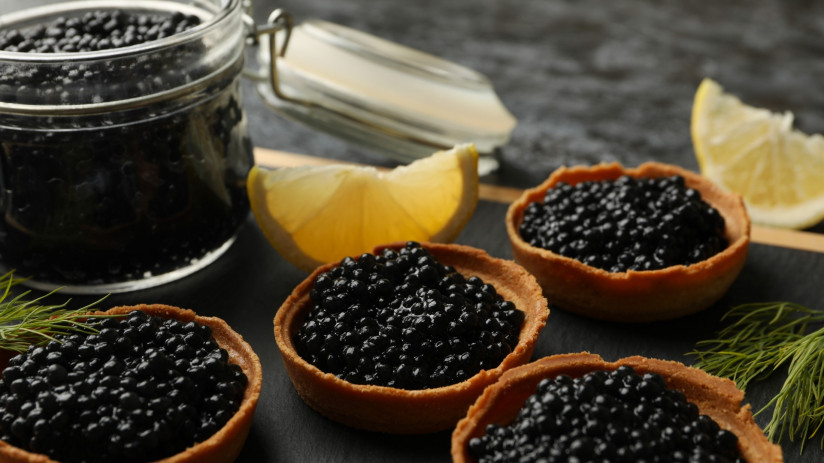 doska-s-tartaletkami-i-bankoi-s-ikroi-na-cernom-dymcatom-fone-krupnym-planom