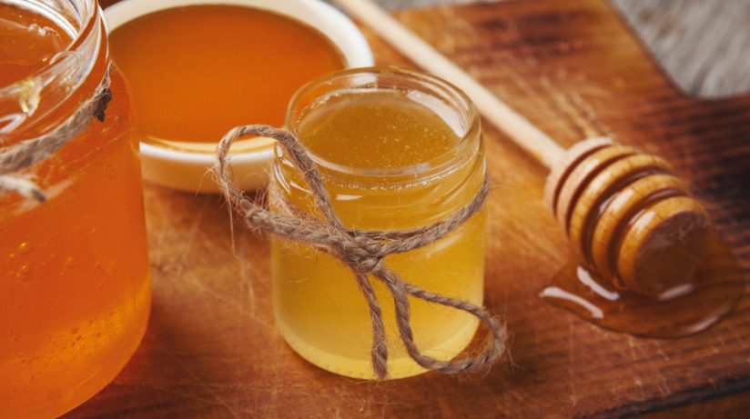 liquid-honey-dipper-rustic-wooden-background-closeup-copy-space