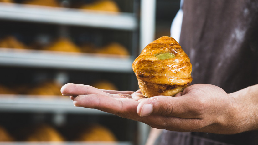 krupnym-planom-muzskoi-pekar-derza-zapecennoe-sladkoe-sloenoe-testo